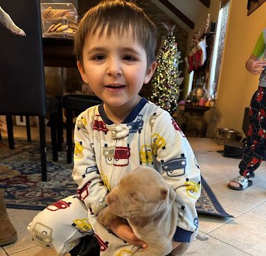 Maryland family smiling with a new Pitbull puppy in their home 